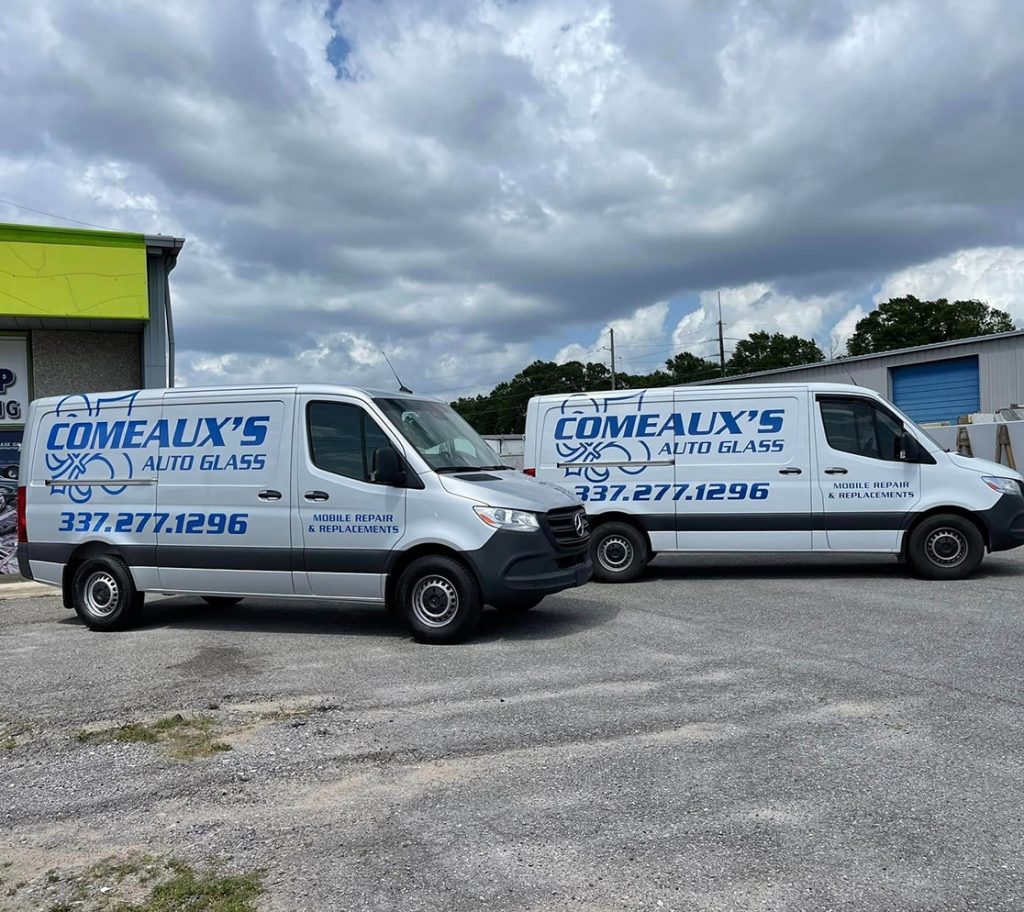 two Comeaux's Auto Glass vans next to each other